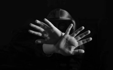 Ciddi, mutsuz, kendine güveni tam iki kolu çapraz tutan, işaret eden, siyah arka plandaki VR cihazına bakan genç bir kız.