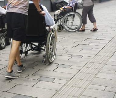 Staten Staten Street 'te tekerlekli sandalyeyi iten birinin ayaklarına yakından bakın. Tekerlekli sandalyenin arkasındaki çocuk ve büyükbabası.