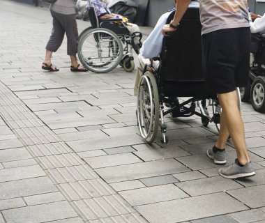 Staten Staten Street 'te tekerlekli sandalyeyi iten birinin ayaklarına yakından bakın. Tekerlekli sandalyenin arkasındaki çocuk ve büyükbabası.