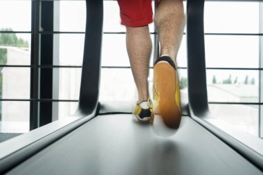 Sporcu fundalık için koşu pistini kullanıyor. spor, fitness, yaşam tarzı, teknoloji ve insan konsepti