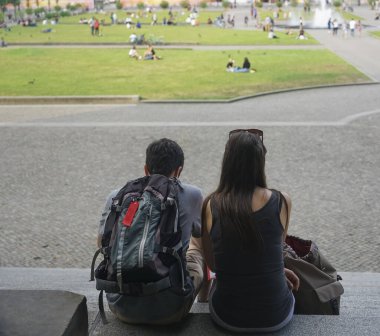 Young happy couple sitting at stone stairs. Berlin, Germany. 