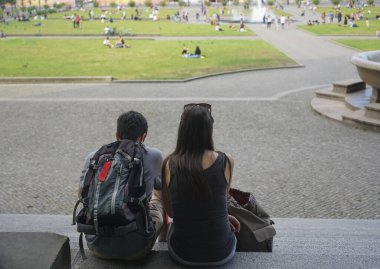 Young happy couple sitting at stone stairs. Berlin, Germany. 