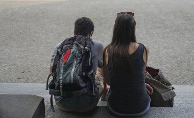 Young happy couple sitting at stone stairs. Berlin, Germany. 