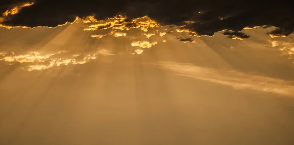 Sun Rays falling through the Clouds. Sea landscape with bad weather and the cloudy dramatic sky. Rays of the sun breaking through the clouds. sunset background.