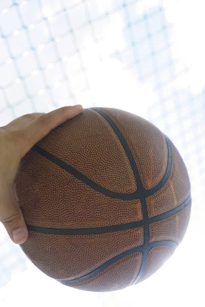 male hand holding basketball ball