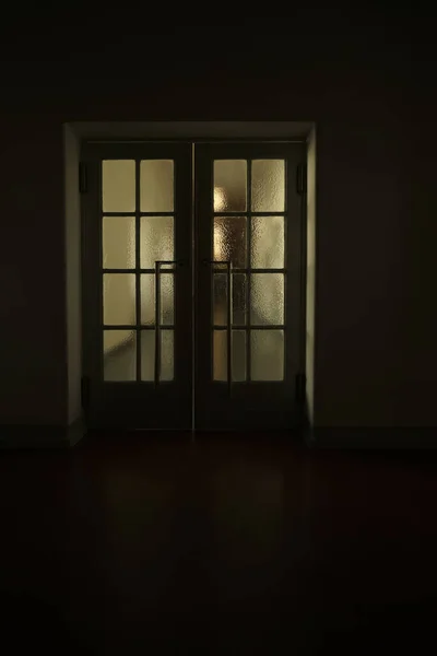 穿过走廊的门照明 有一扇门的古建筑里狭窄的黑暗走廊 有两扇门开着 从里面透出明亮的光线 明亮的灯光点缀在墙上和地板上 — 图库照片