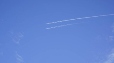 İki uçak beyaz bir iz bırakarak paralel olarak uçan parlak güneşli bir günde. 