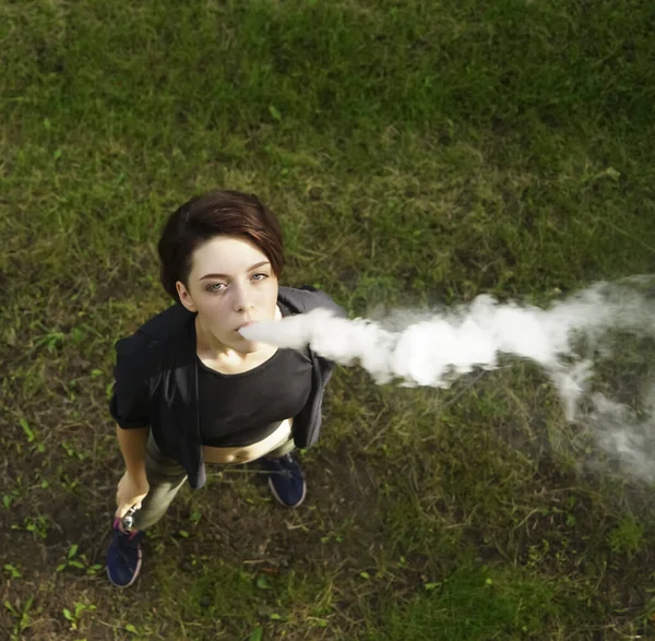 Mladá Dívka Kouří Elektronickou Cigaretu Teenagerl Vaporizer Zeleném Travnatém Pozadí — Stock fotografie