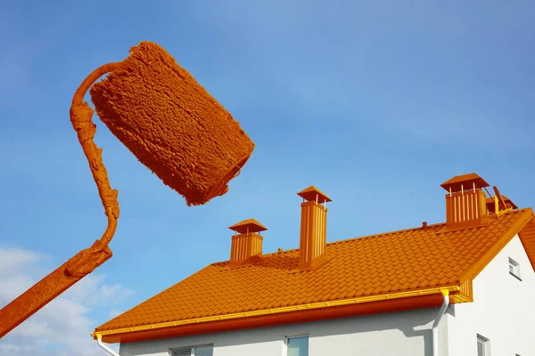 Professional workman is painting exterior walls and window frames of ancient house at scaffold tower, outside home renovation in close up under sunny. blue sky background.