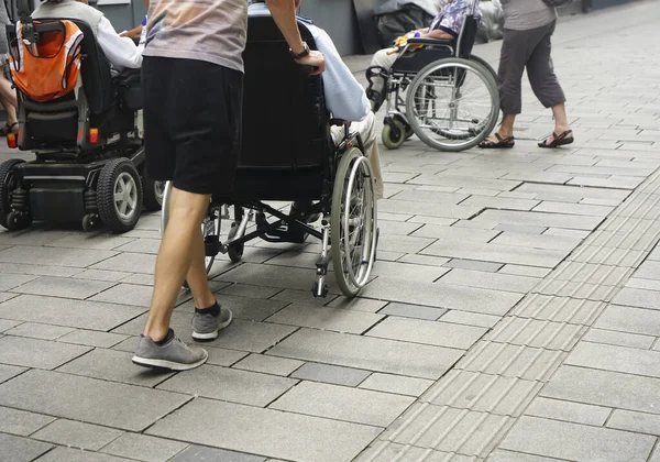 Vista Cerca Los Pies Una Persona Empujando Una Silla Ruedas —  Fotos de Stock