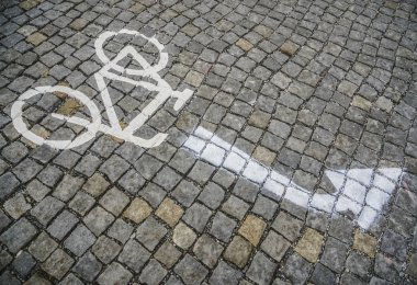 Sokakta bisiklet yolu var. Bisiklet ve hareket işaretli yol taşı fayans şeridi. resim oku