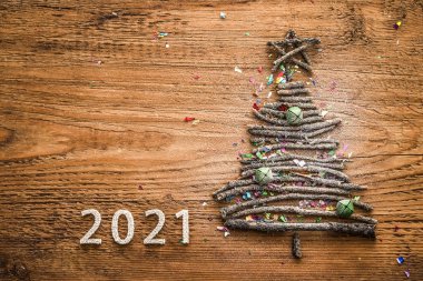 tree  from many dry Stick snowy Christmas. Wood star, bell toys on old retro vintage style wooden texture background. happy new year 2021  holiday