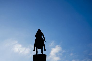 Silhouette of a rider on a horse on blue sky background. legs in stirrups, dagger in hand. Leopold's Fountain in Innsbruck, Austria