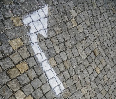 Beyaz ok eski eski kaldırım taşlarına boyanmış.. 