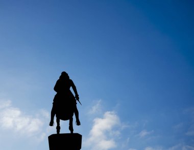 Silhouette of a rider on a horse on blue sky background. legs in stirrups, dagger in hand. Leopold's Fountain in Innsbruck, Austria