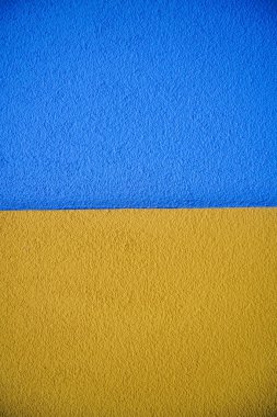 Beton duvarın mavi ve sarı yüzeyi. Renkli boyalı arkaplan. 