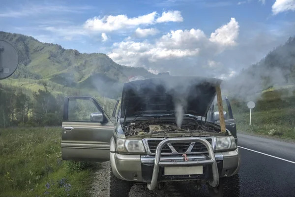 Yaz dağlar karşı ısınmış Suv araba ayakta. Smokey araba motoru. Altay, Rusya Federasyonu