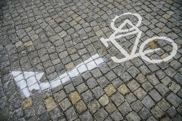 街上的自行车道 道路石砖车道与自行车和移动指针标记 喷漆箭 — 图库照片