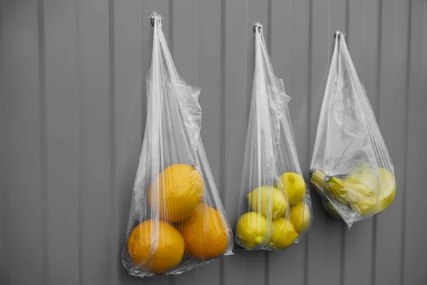 Tres Bolsas Plástico Con Frutas Naranjas Plátanos Limones Sobre Fondo — Foto de Stock