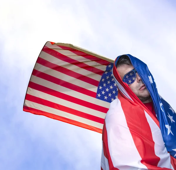 美利坚合众国独立日 用美国国旗包裹的成年人站在乌云密布的蓝天背景下 用Usa国旗包裹在天空背景下的年轻人 — 图库照片
