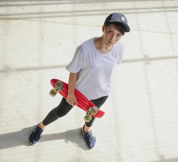 portrait of teen girl with long skate board stand against gray wall. Outdoors, urban lifestyle. top view. Youth subculture.