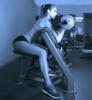 Spor salonunda egzersiz yapan genç bir kadın..  