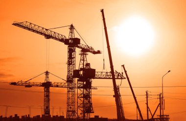Akşam gökyüzü arkaplanına vinç inşaatı İnşaat alanı
