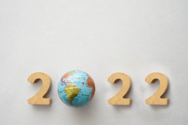 Mutlu yıllar 2022. Yuvarlak dünya haritası beyaz arka planda izole edildi. Yazı veya nesneler için boş kopyalama alanı.