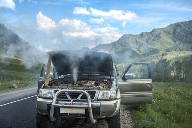 overheated car in the field, bright sunlight, steam under the ho