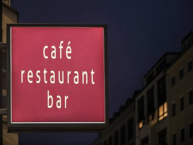 Kafe, restoran, bar neon kırmızısı ya da pembe tabela. Gece parlak bir işaret. Geceleri neon. Boş Işık Kutusu imzası duvarda asılı. Gece şehir hayatı.