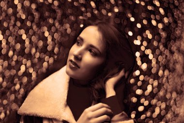 Güzel Asyalı kız şafak vakti şehir sokağına bakıyor. Bokeh ile arkaplan. 