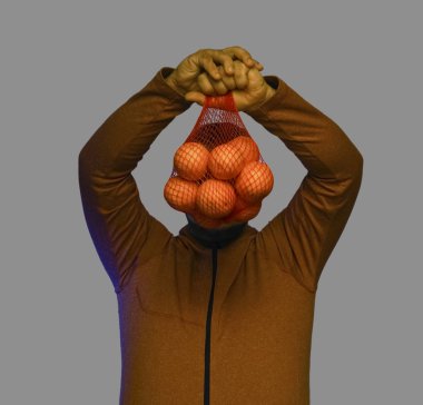 Ağın içinde portakal tutan bir adam.