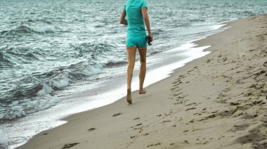 Deniz kıyısında koşan bir kadın. Yalınayak kız. 