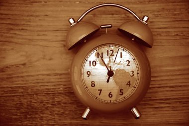 Kaliteli saat ve çalar saat ahşap masa arka planında. kadrandaki küresel harita küresi