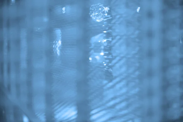 blurred white metallic mesh that have some spider web, with blur  defocused as background