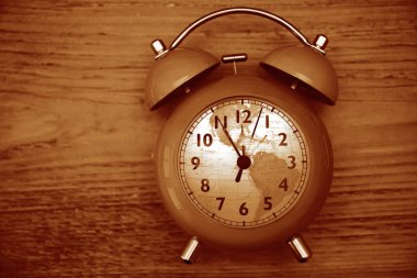 Kaliteli saat ve çalar saat ahşap masa arka planında. kadrandaki küresel harita küresi