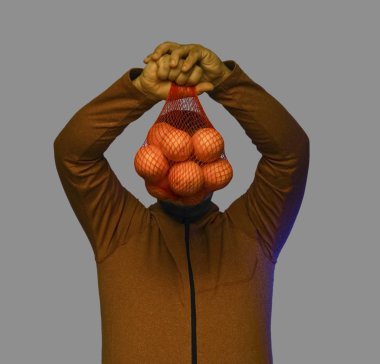 Ağın içinde portakal tutan bir adam.