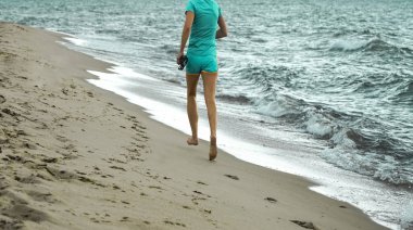 Deniz kıyısında koşan bir kadın. Yalınayak kız. 