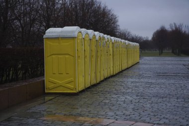 Parktaki kuru dolapların sarı kulübeleri. Moskova, Rusya. Yağmurlu günlerde parkta gezici tuvaletler.