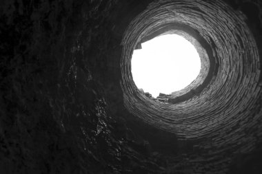  Kanalizasyon çukurunun üst görüntüsü. Erişim çukurunda. Kanalizasyon deliği. Eski kırmızı tuğla tüp şaftın içinde. Fabrika tuğlası boru, içeriden görüş. patlama fırını