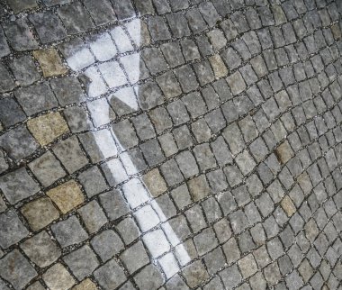 Beyaz ok eski eski kaldırım taşlarına boyanmış.. 