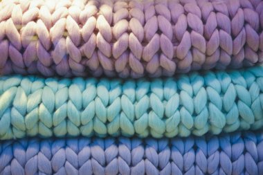 Büyük katlanmış battaniyeler, dev örgü battaniyeler, süper tombul iplik, kol örgü. yeşil, mavi ve mor renkler.