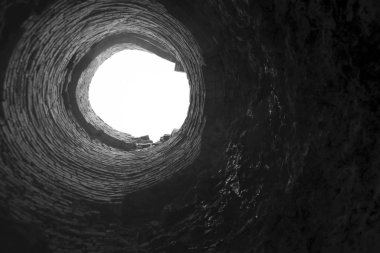  Kanalizasyon çukurunun üst görüntüsü. Erişim çukurunda. Kanalizasyon deliği. Eski kırmızı tuğla tüp şaftın içinde. Fabrika tuğlası boru, içeriden görüş. patlama fırını