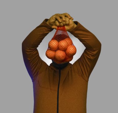 Ağın içinde portakal tutan bir adam.