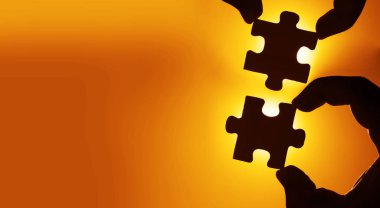 Gökyüzü arka planında yapboz parçaları olan eller.  