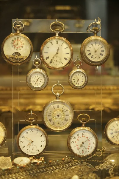 golden Antique pocket watches There are many displays in the showcase. retro, vintage pocket watches on a shopfront.