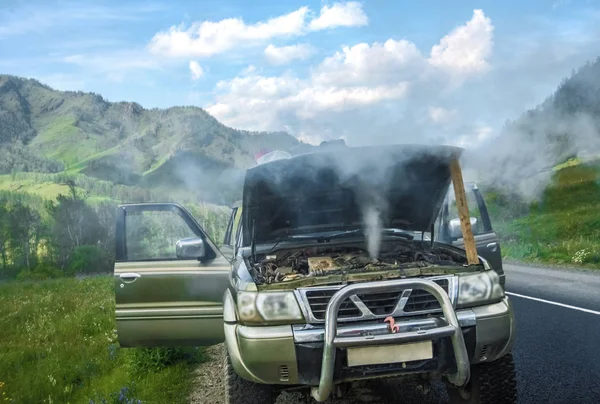 overheated car in the field, bright sunlight, steam under the ho