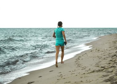 Deniz kıyısında koşan bir kadın. Yalınayak kız. 