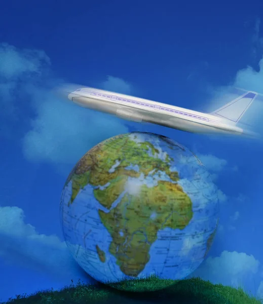 toy plane on the globe. Flight travel concept. Travel by airplane. Takeoff and landing of the aircraft. Return home from flight. empty Copy space. green grass meadow and blue cloudy sky.
