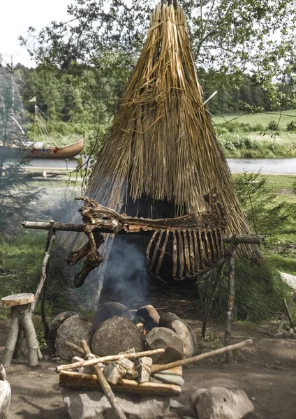 在小屋前的火石器时代食品烹饪 — 图库照片